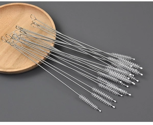 Detail of stainless steel straw cleaning brushes with soft bristles on a wooden tray