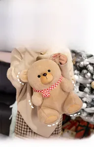 Detailed texture of brown teddy bear plush with red and white checkered scarf