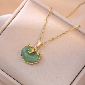 Traditional Chinese Ruyi lock necklace in gold and green jade finish on a jewelry box