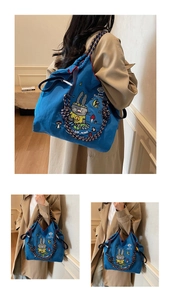 Detail of navy canvas tote bag with rabbit illustration and multi-color braided rope handle