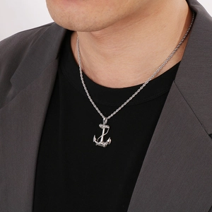 Men's silver anchor pendant necklace with rope chain worn on a grey blazer suit