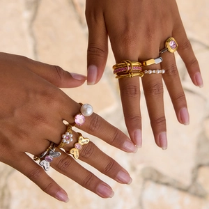 Elegant gold and silver ring set with pink gemstones and pearls on model hands