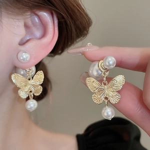 French vintage gold butterfly earrings with faux pearls shown on model and in detail
