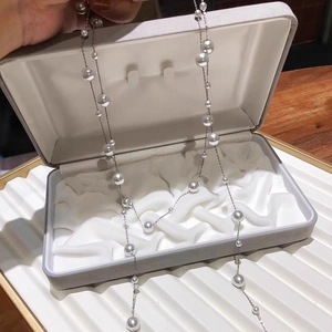 Elegant multi-layered long pearl station necklace featuring glossy white glass beads