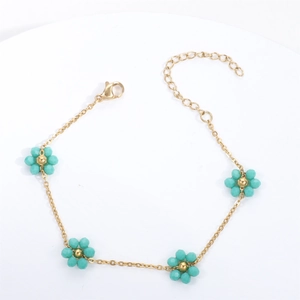 Detailed shot of golden chain bracelet with green crystal flowers and lobster clasp