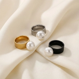 Minimalist stainless steel rings with large pearls on ivory satin in gold silver and black
