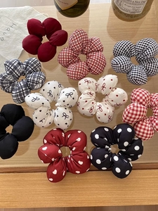 Detailed set of floral and checkered pattern sponge hair scrunchies on wooden tray