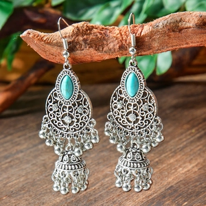 Detail of vintage bohemian silver Jhumka earrings with turquoise and metallic tassels