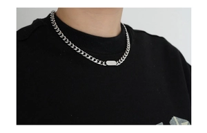 Close-up of a silver titanium steel Cuban chain necklace with a rectangular pendant