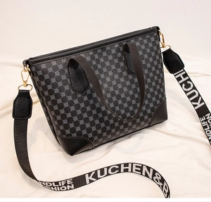 Detail view of large tote bag with geometric print, leather base, and branded strap