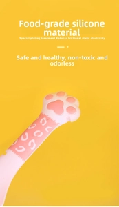 Detail of pink silicone paw-shaped spoon made of food-grade material with leopard pattern