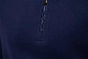 Detailed close-up of navy blue men's half-zip sweatshirt with high-quality metal zipper
