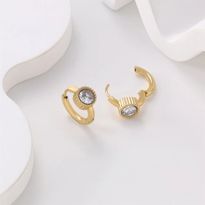 Macro shot of 18K gold plated stainless steel earring with round zircon and gear bezel