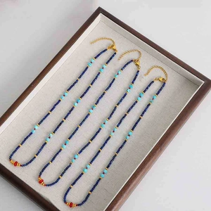 Detail of three handmade bohemian beaded necklaces with colorful stones and gold clasp