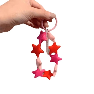 Handheld colorful silicone star keychain with red and pink beads and a round clasp