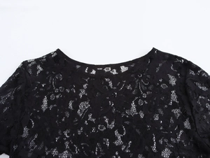 Detail shot of black lace fabric texture and round neckline of a French style dress