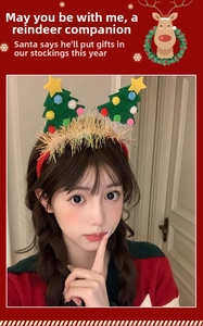 Close-up of a festive headband with green plush Christmas trees and colorful pom-poms