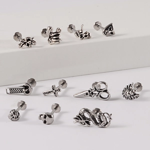 Set of 12 stainless steel lip studs featuring skull, snake, and cross gothic designs