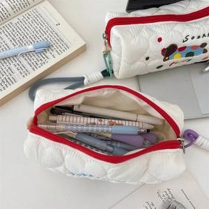 Close-up of a white quilted pencil case with cute dog embroidery and large storage capacity