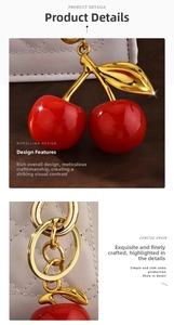 Macro shot of red cherry bag charm with golden metal leaves on white quilted leather