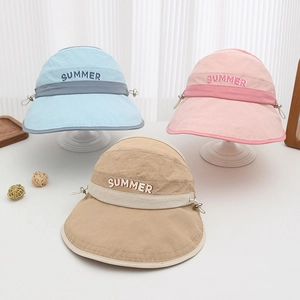 Close-up of children's summer sun hats in blue, pink, and khaki with SUMMER lettering