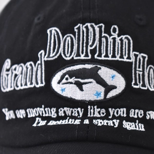 Close-up of dolphin embroidery and Grand Dolphin text on vintage washed cotton baseball cap