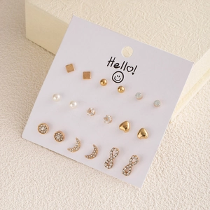 Detail of assorted gold and silver earring set with pearls and rhinestones on display card