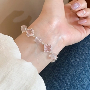Detail of pink four-leaf clover bracelet with white and pink crystal beads on a wrist