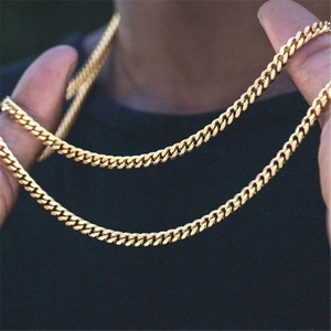 Polished golden stainless steel Cuban link chains shown worn on a male model