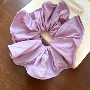 Détail d'un chouchou surdimensionné lilas sur un livre vintage avec perles
