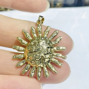 Detailed macro view of a gold sunflower pendant with embossed texture and zircon inlay