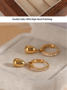 Detail of gold hoop earrings with sparkling zircon and water drop pendants in a jewelry box