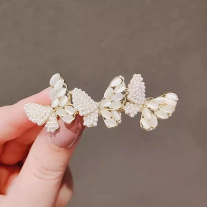 Elegant gold butterfly hair clip featuring shell wings and small pearls for women