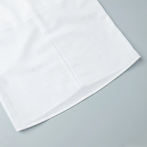 Detailed view of the fine cotton-linen fabric texture and neat stitching on a white dress