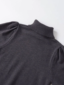 Detailed view of dark grey puff sleeve knit top featuring a ribbed turtleneck collar