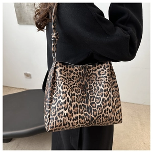 Detail view of stylish leopard print tote bag worn on shoulder in a minimalist studio