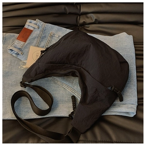 Vista dall'alto della borsa a mezzaluna in nylon nero su denim e pelle in stile street