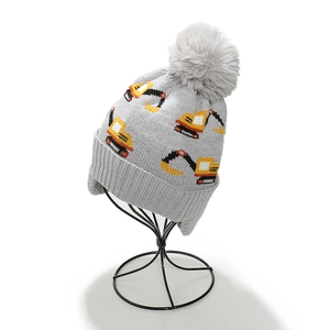 Grey knitted kids earflap hat with yellow excavator pattern and large faux fur pompom