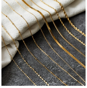 Detailed close-up of various gold-plated stainless steel chains on textured background