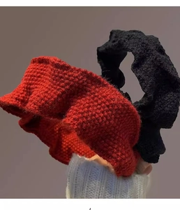 Detailed close-up of red and black chunky knit headbands with intricate crochet texture