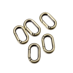 Five antique bronze oval spring snap hooks with brushed metal texture for bags