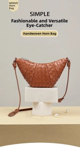 Detail of caramel brown woven leather croissant bag with iconic knot strap on stone base