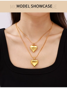 Detailed view of 18k gold plated hollow heart pendants on double layered necklaces