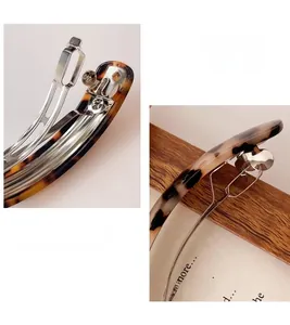 Macro detail of amber tortoise shell pattern hair clip with metallic spring mechanism