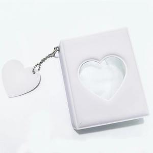Detail of white mini photo album with heart-shaped cutout and silver bead chain pendant