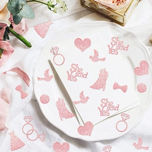 Pink glitter bridal shower table confetti with hearts, wedding dress and rings