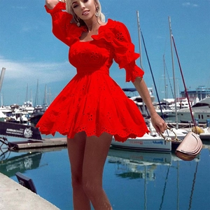 Red cutout embroidery mini dress with puff sleeves against a scenic boat dock background