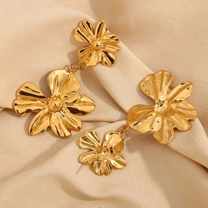 Fashionable 18K gold-plated stainless steel double flower earrings on silk background