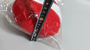 Detail view of plush Christmas tree leg decoration showing 15cm dimensions with a tape measure