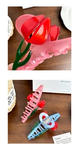 Detail of tulip shaped hair claws in red, pink and blue colors with glossy resin finish